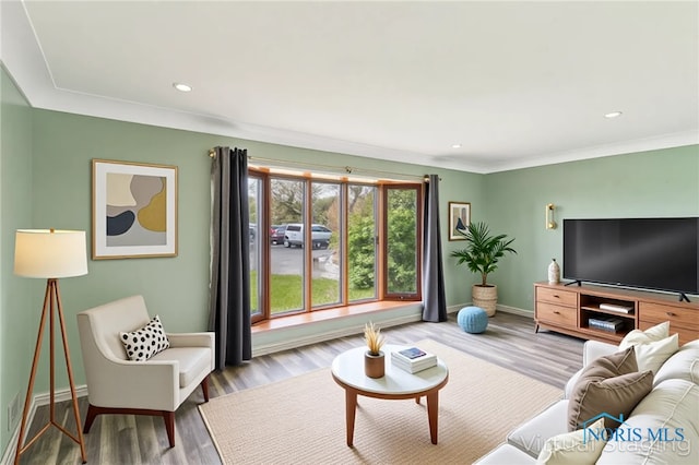 living room featuring crown molding, recessed lighting, baseboards, wood finished floors, and visible vents