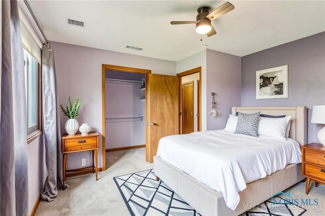 bedroom featuring visible vents, a ceiling fan, a closet, and light colored carpet