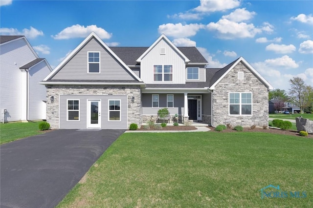 craftsman inspired home with board and batten siding, a front lawn, and stone siding
