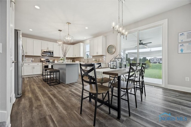 dining room featuring recessed lighting, baseboards, ceiling fan with notable chandelier, and dark wood-type flooring
