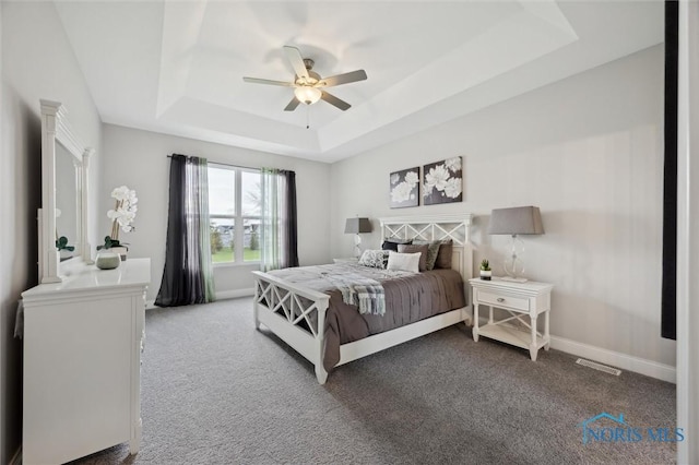 bedroom featuring baseboards, carpet flooring, a raised ceiling, and visible vents
