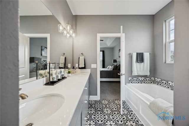 ensuite bathroom with a sink, a garden tub, ensuite bath, and double vanity