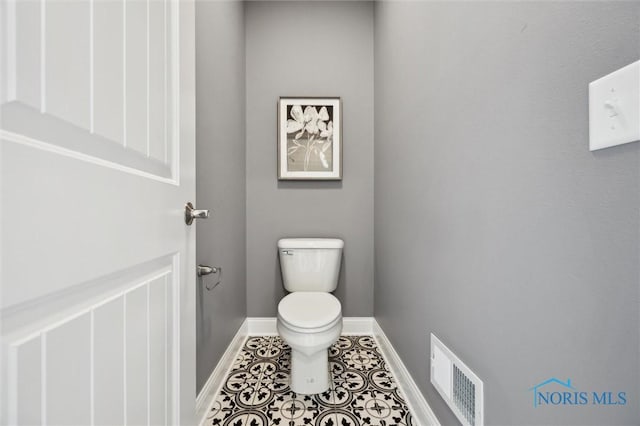 bathroom with toilet, baseboards, visible vents, and tile patterned floors