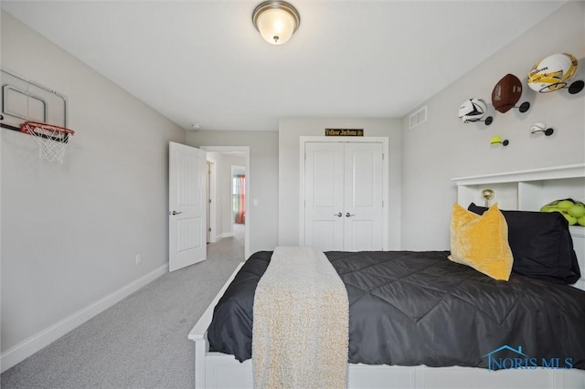carpeted bedroom featuring visible vents, baseboards, and a closet