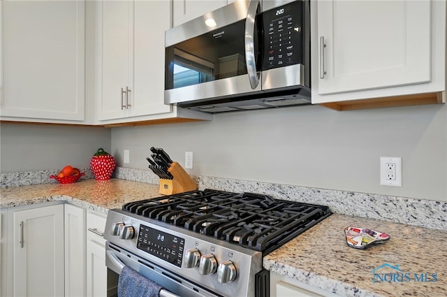 kitchen featuring stainless steel appliances and white cabinetry