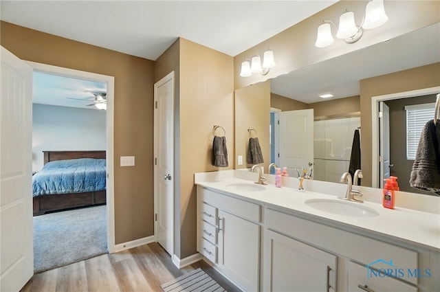 ensuite bathroom featuring ceiling fan, a sink, ensuite bathroom, and wood finished floors