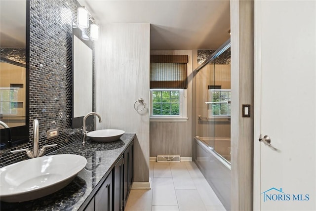 5258 Coldstream Rd, Toledo, OH 43623 - full bath featuring tile patterned floors, backsplash, double vanity, and bath / shower combo with glass door