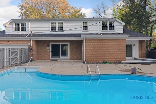 5258 Coldstream Rd, Toledo, OH 43623 - back of property with brick siding, a patio area, an outdoor pool, and roof with shingles