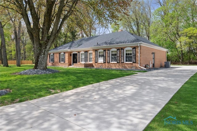 5258 Coldstream Rd, Toledo, OH 43623 - single story home with brick siding, central air condition unit, concrete driveway, a front lawn, and a chimney
