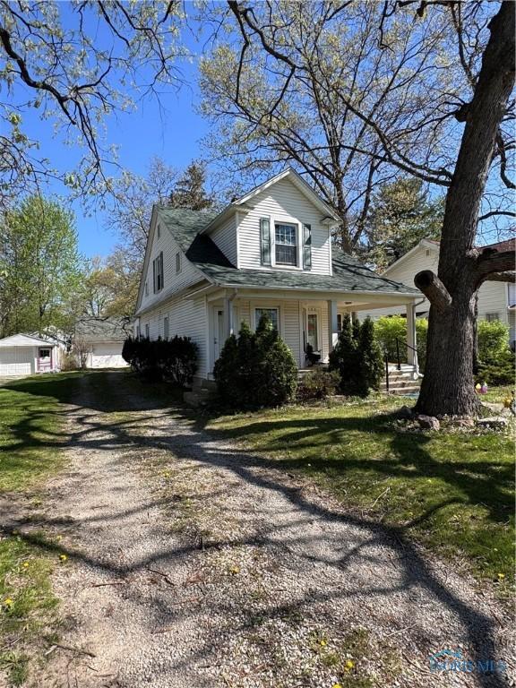 view of home's exterior with a lawn and a porch