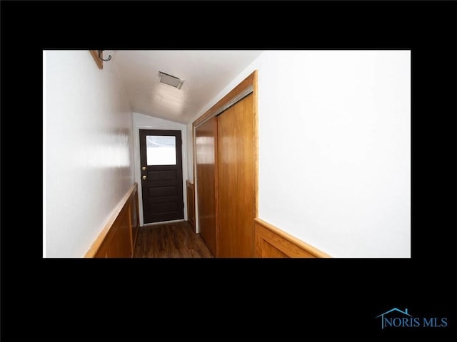 doorway featuring visible vents, wood finished floors, and lofted ceiling