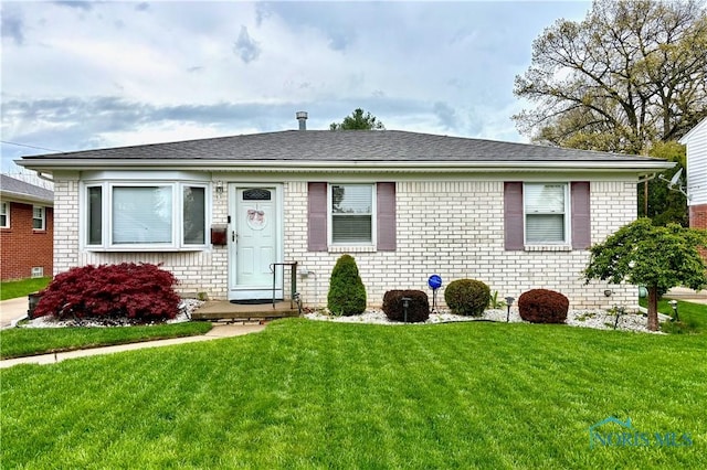 view of front of home with brick siding and a front lawn