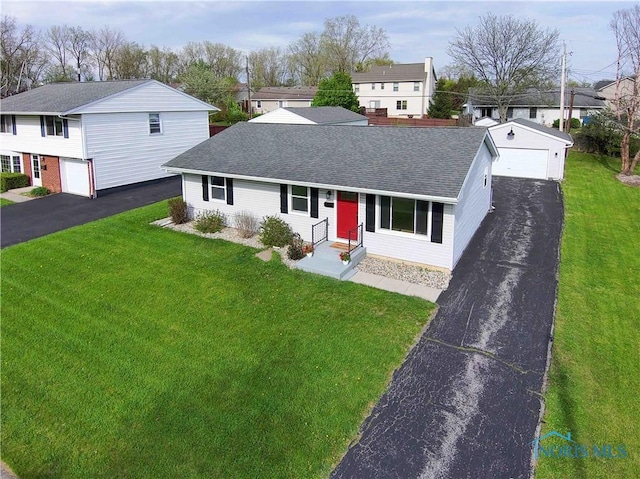 view of front facade featuring entry steps, a shingled roof, a front yard, and a garage