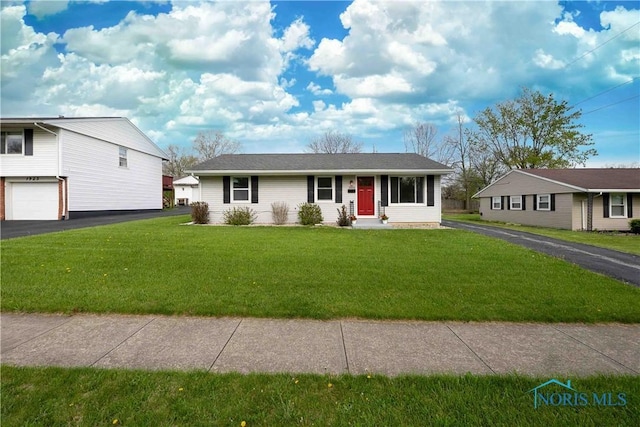 single story home featuring a garage, a front yard, and aphalt driveway