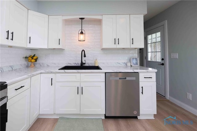 kitchen with a sink, backsplash, light wood finished floors, and dishwasher