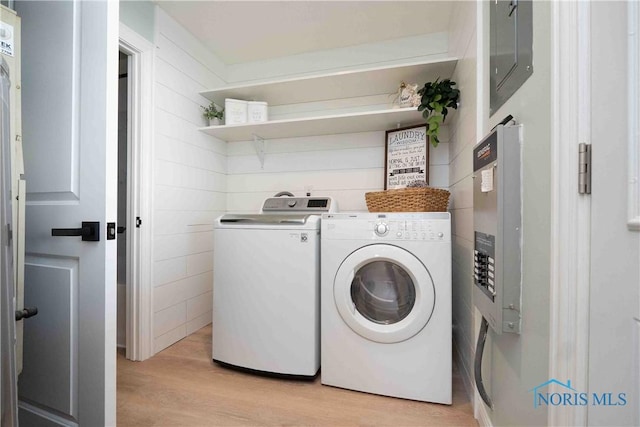 clothes washing area featuring light wood-type flooring and separate washer and dryer