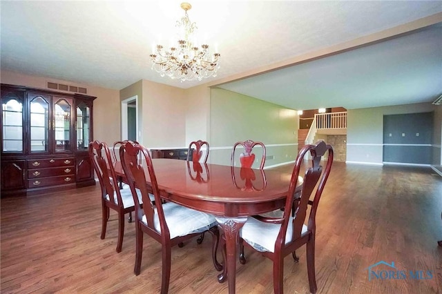 dining room featuring visible vents, baseboards, wood finished floors, and an inviting chandelier