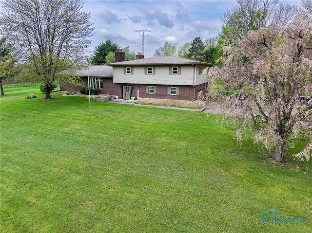 1440 N State Route 19, Republic, OH 44867 - rear view of house featuring a chimney, a yard, and brick siding