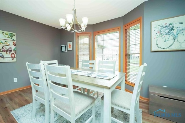 2028 Lakeland Dr, Findlay, OH 45840 - dining area with an inviting chandelier, baseboards, wood finished floors, and a wealth of natural light