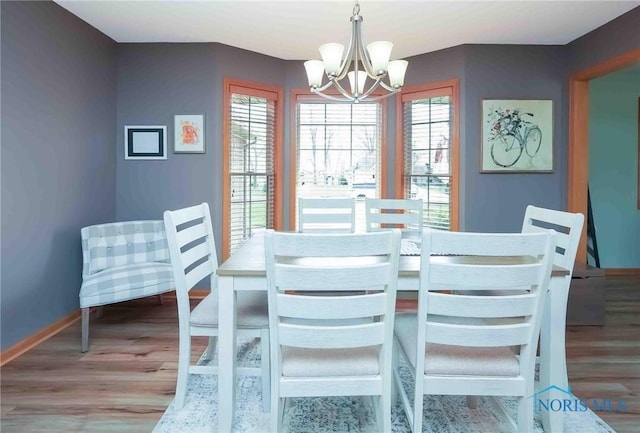 2028 Lakeland Dr, Findlay, OH 45840 - dining room with baseboards, a wealth of natural light, wood finished floors, and a chandelier
