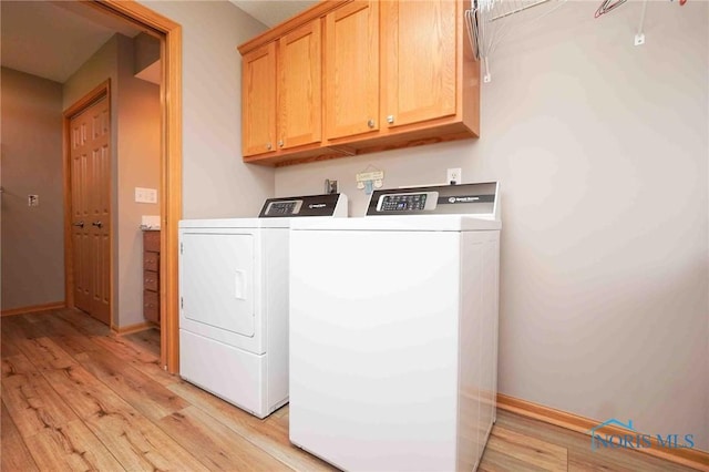 2028 Lakeland Dr, Findlay, OH 45840 - washroom featuring baseboards, cabinet space, light wood finished floors, and washing machine and dryer