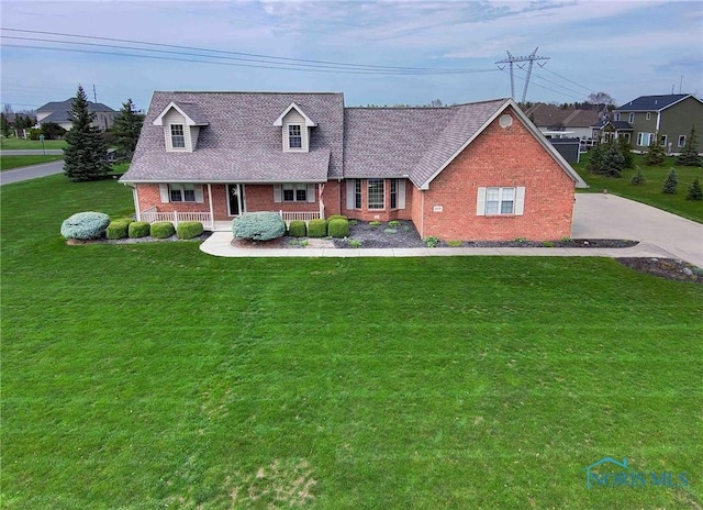 cape cod-style house with covered porch, brick siding, and a front lawn
