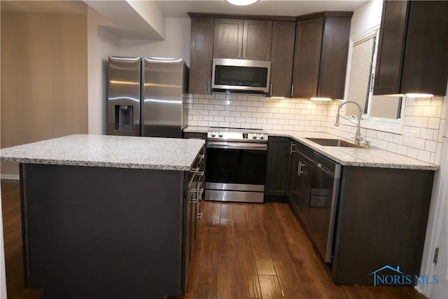 6553 Abbey Run Unit D13, Sylvania, OH 43560 - kitchen featuring dark wood-style flooring, appliances with stainless steel finishes, a center island, dark brown cabinets, and a sink
