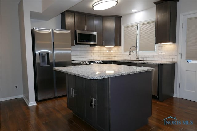 6553 Abbey Run Unit D13, Sylvania, OH 43560 - kitchen with dark wood-style flooring, a center island, light stone counters, a sink, and appliances with stainless steel finishes