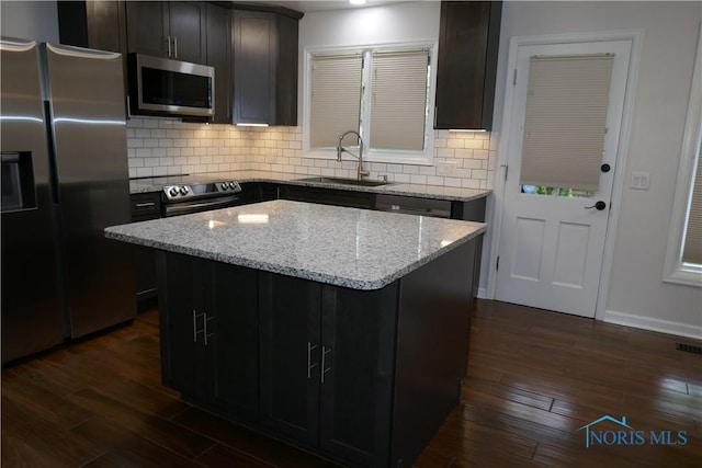 6553 Abbey Run Unit D13, Sylvania, OH 43560 - kitchen featuring a kitchen island, appliances with stainless steel finishes, tasteful backsplash, dark wood finished floors, and a sink