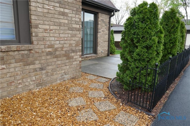 6553 Abbey Run Unit D13, Sylvania, OH 43560 - view of side of home featuring fence, a patio area, and brick siding