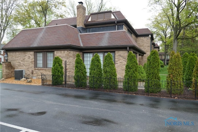 6553 Abbey Run Unit D13, Sylvania, OH 43560 - exterior space featuring brick siding, central AC unit, fence, and a chimney