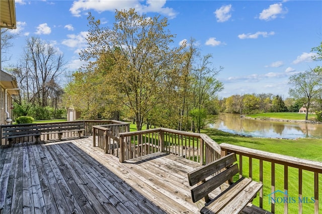 wooden deck featuring a lawn and a water view