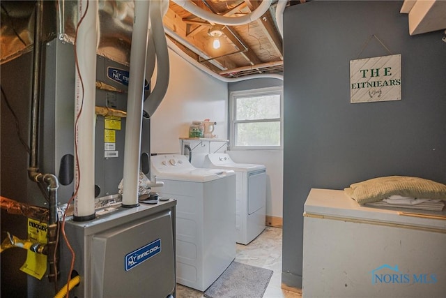 clothes washing area with laundry area, heating unit, and washer and dryer