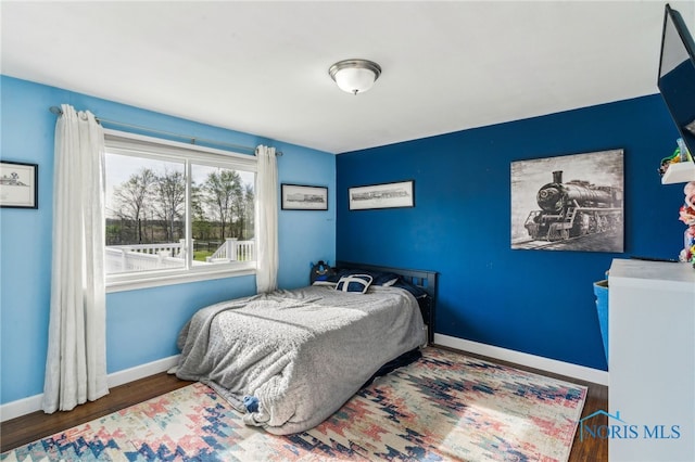 bedroom with baseboards and wood finished floors
