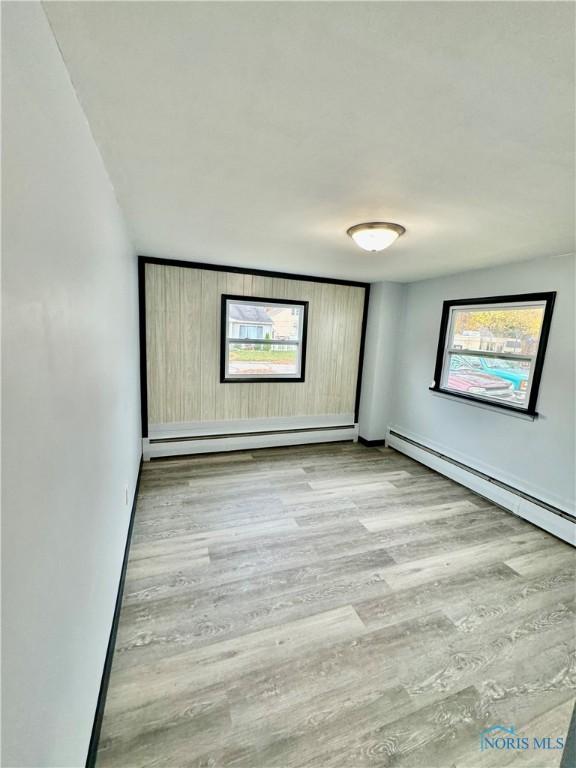 312 Minneapolis St, Defiance, OH 43512 - empty room featuring baseboards, baseboard heating, and wood finished floors