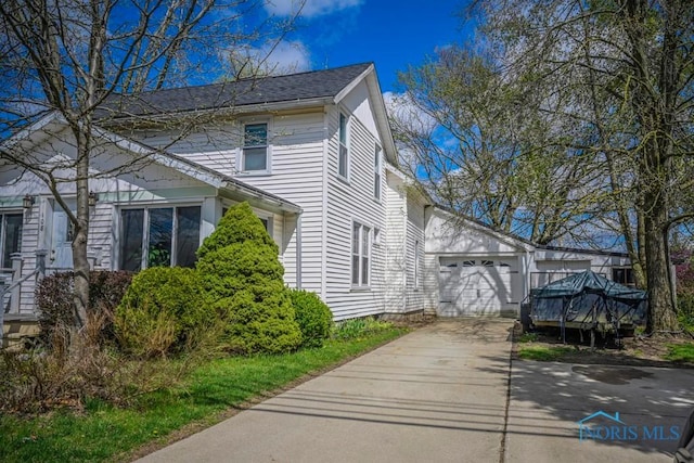 view of property exterior featuring a garage and driveway