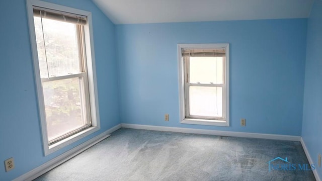 empty room with baseboards, a healthy amount of sunlight, and lofted ceiling