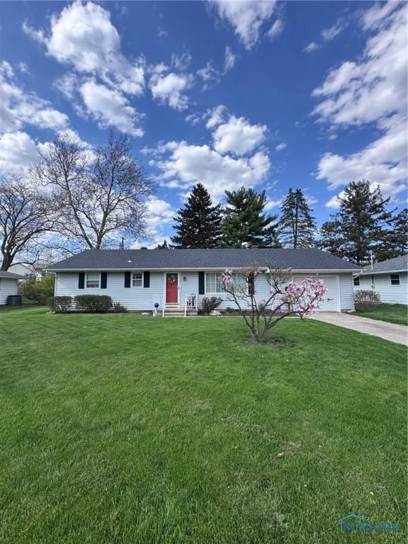 ranch-style home with an attached garage, concrete driveway, and a front lawn