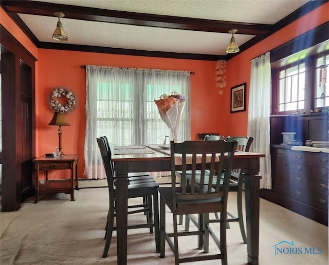 dining space with light colored carpet, ornamental molding, a textured ceiling, and beam ceiling