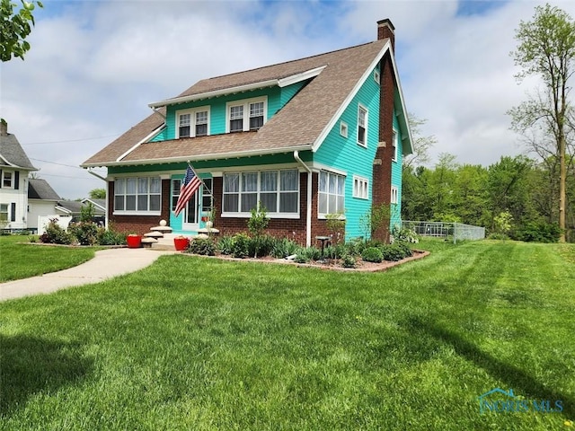 602 W Main St, Fayette, OH 43521 - view of front of house featuring brick siding, a chimney, and a front yard