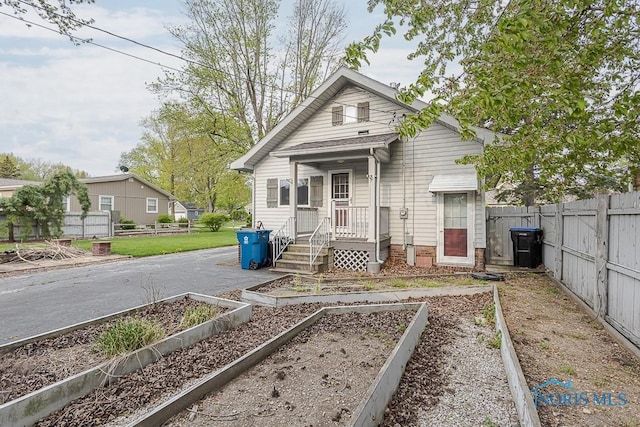 view of front of property featuring fence and a vegetable garden