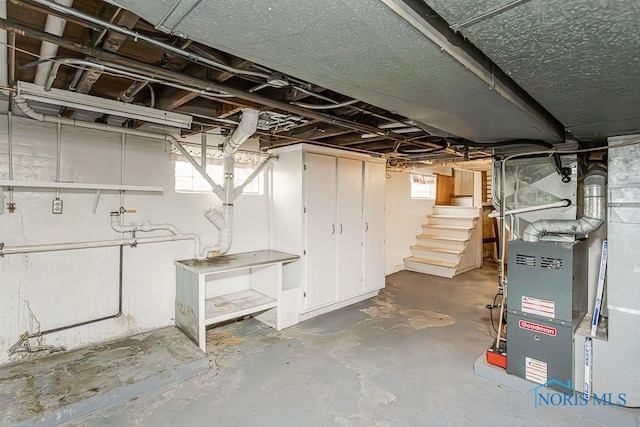basement with heating unit and stairway