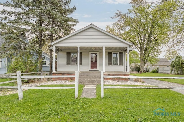 bungalow-style home featuring fence, a porch, and a front lawn