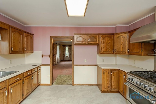 kitchen featuring brown cabinetry, light countertops, high end stainless steel range oven, and wall chimney range hood