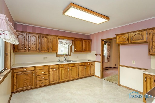 kitchen featuring brown cabinetry, a sink, and light floors