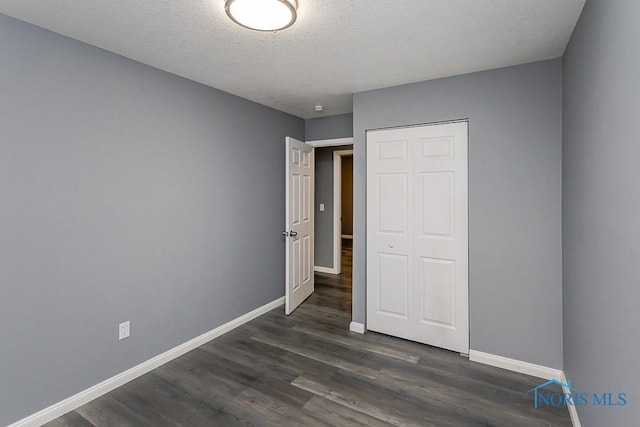 2509 Orchard Hills Blvd, Toledo, OH 43615 - unfurnished bedroom with baseboards, dark wood-type flooring, a closet, and a textured ceiling