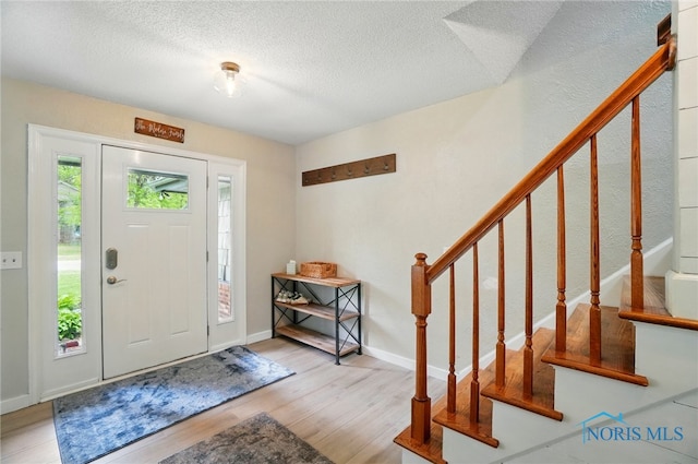 2369 Saint James Woods Blvd, Toledo, OH 43617 - entrance foyer with stairs, wood finished floors, a textured ceiling, and baseboards