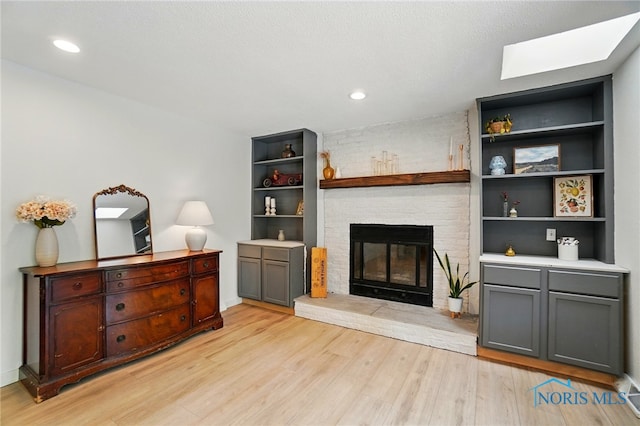 2369 Saint James Woods Blvd, Toledo, OH 43617 - living room featuring light wood finished floors, a brick fireplace, built in shelves, and recessed lighting
