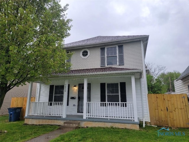view of front of house featuring fence and covered porch