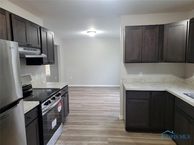 kitchen with dark brown cabinets, light wood-style floors, baseboards, under cabinet range hood, and appliances with stainless steel finishes